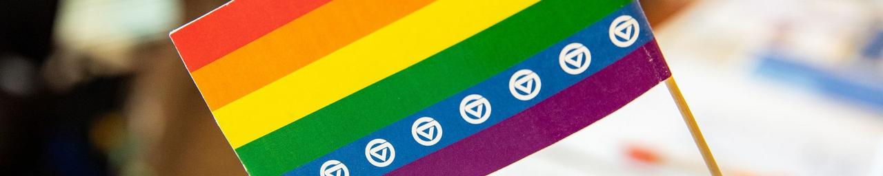 LGBTQ pride flag with GVSU logos on the blue stripe